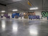 a parking garage with lots of graffiti written on the wall and floors of it,