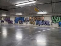 a parking garage with lots of graffiti written on the wall and floors of it,