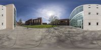 a circular panoramic view of a building and the reflection of a man walking on the street