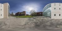 a circular panoramic view of a building and the reflection of a man walking on the street