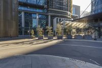 a circular structure that is outside in the sun with large windows and several planters