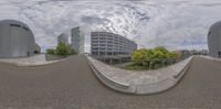 the view of a street with buildings through the fish eye lenses of this camera