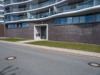 the building has a window above the entrance on this sidewalk near a street in front of the building