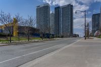 a view of a empty city street next to tall buildings and a street light on a corner