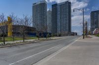 a view of a empty city street next to tall buildings and a street light on a corner