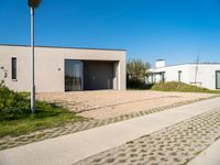 the courtyard area features a cement pavers pathway leading to a building with an open garage and several windows