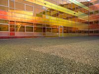 an outside picture of an urban area with orange sky in the background with yellow colored light reflecting off it's windows