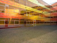 an outside picture of an urban area with orange sky in the background with yellow colored light reflecting off it's windows