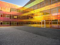 an outside picture of an urban area with orange sky in the background with yellow colored light reflecting off it's windows