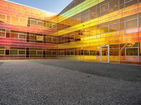 an outside picture of an urban area with orange sky in the background with yellow colored light reflecting off it's windows