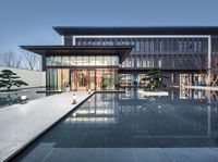 the outside patio of this modern home is reflected in the water and stone tiles on the ground