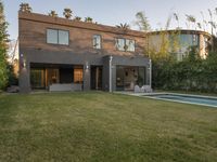 a large modern home sitting next to a swimming pool in the front yard with trees