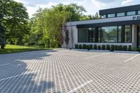 a modern white home with a paved driveway and large windows overlooking the view in a nice landscape