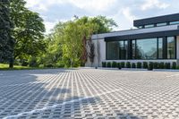 a modern white home with a paved driveway and large windows overlooking the view in a nice landscape