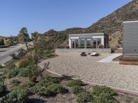 two modern homes with a gravel patio and mountain view area in the background from the air above