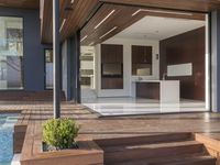 a view out onto the trees of a large modern house in california city, with an outdoor deck with wooden benches and stairs