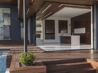 a view out onto the trees of a large modern house in california city, with an outdoor deck with wooden benches and stairs