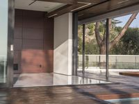 a view out onto the trees of a large modern house in california city, with an outdoor deck with wooden benches and stairs