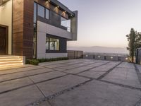 the exterior and landscape of a modern house in los angeles, california with stone and wood