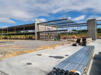 the construction site for a modern house under construction with a long metal pipe on the concrete floor