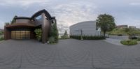 a 360 lens photo of a large modern house with driveway in front of it and landscaping