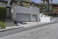 a house with a garage on one side and steps to the other on a steep slope