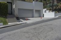 a house with a garage on one side and steps to the other on a steep slope