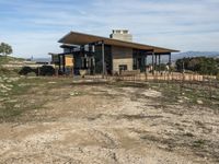 a big house sitting on top of a hill near dirt and grass in the country