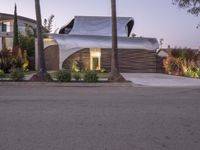 a house that is next to two palm trees with a white canopy attached to it