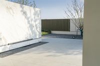 the outside courtyard of an all white modern house in palm springs florida with concrete bench and trees