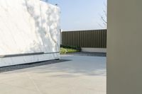 the outside courtyard of an all white modern house in palm springs florida with concrete bench and trees