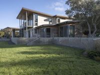 the house with large grass lawn is surrounded by plants and landscaping in a modern house