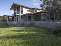 the house with large grass lawn is surrounded by plants and landscaping in a modern house