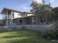 the house with large grass lawn is surrounded by plants and landscaping in a modern house