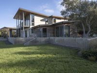 the house with large grass lawn is surrounded by plants and landscaping in a modern house