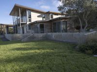 the house with large grass lawn is surrounded by plants and landscaping in a modern house