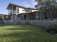 the house with large grass lawn is surrounded by plants and landscaping in a modern house