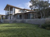 the house with large grass lawn is surrounded by plants and landscaping in a modern house