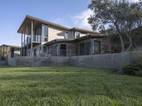 the house with large grass lawn is surrounded by plants and landscaping in a modern house