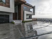 a modern house that has been designed on a steep hillside on a cloudy day with the roof still clear