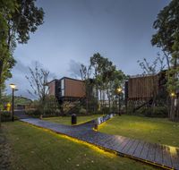 the modern house sits in the middle of the garden, and it's lit up at night