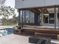 a modern house sits on the edge of a small pool area and features wood paneled walls