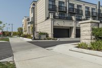 a row of modern housing buildings next to a sidewalk near some bushes and trees on a sunny day