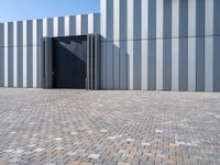 a brick floor and a black gate outside a building for people to see or see