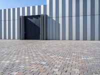 a brick floor and a black gate outside a building for people to see or see