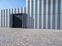 a brick floor and a black gate outside a building for people to see or see