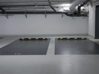 a very empty parking garage with yellow and white lines painted on the floor and ceiling