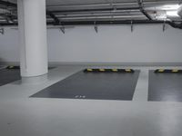 a very empty parking garage with yellow and white lines painted on the floor and ceiling