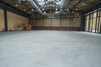 an empty industrial space with exposed brick walls and concrete floors is shown in this photograph