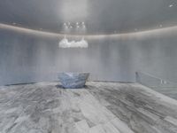 a room that has a lot of grey concrete in it and lighting around the top